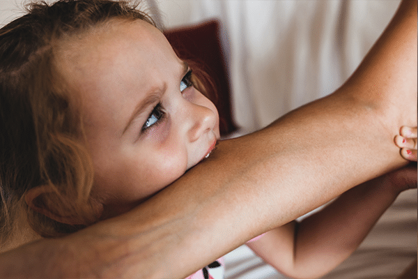 A child biting someone's arm